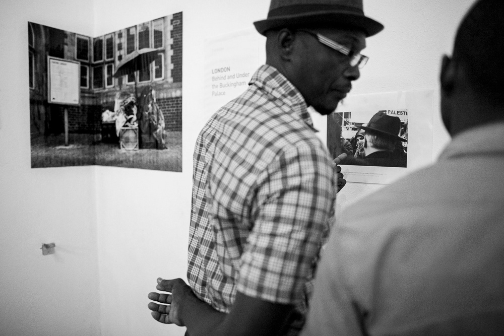 Picture of the frames on the exhibition wall with the caption and also Gallery Attendants at "Londres. Detrás y debajo del palacio de buckingam" exhibition space. gallery arte soy in santiago de cuba, cuba. 2015  © Pedro Rodrigues